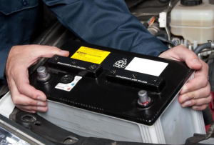 man putting car battery in